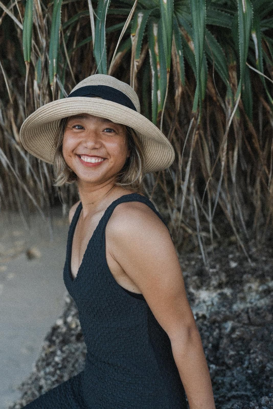 Saya, yoga teacher, smiling in soft light.